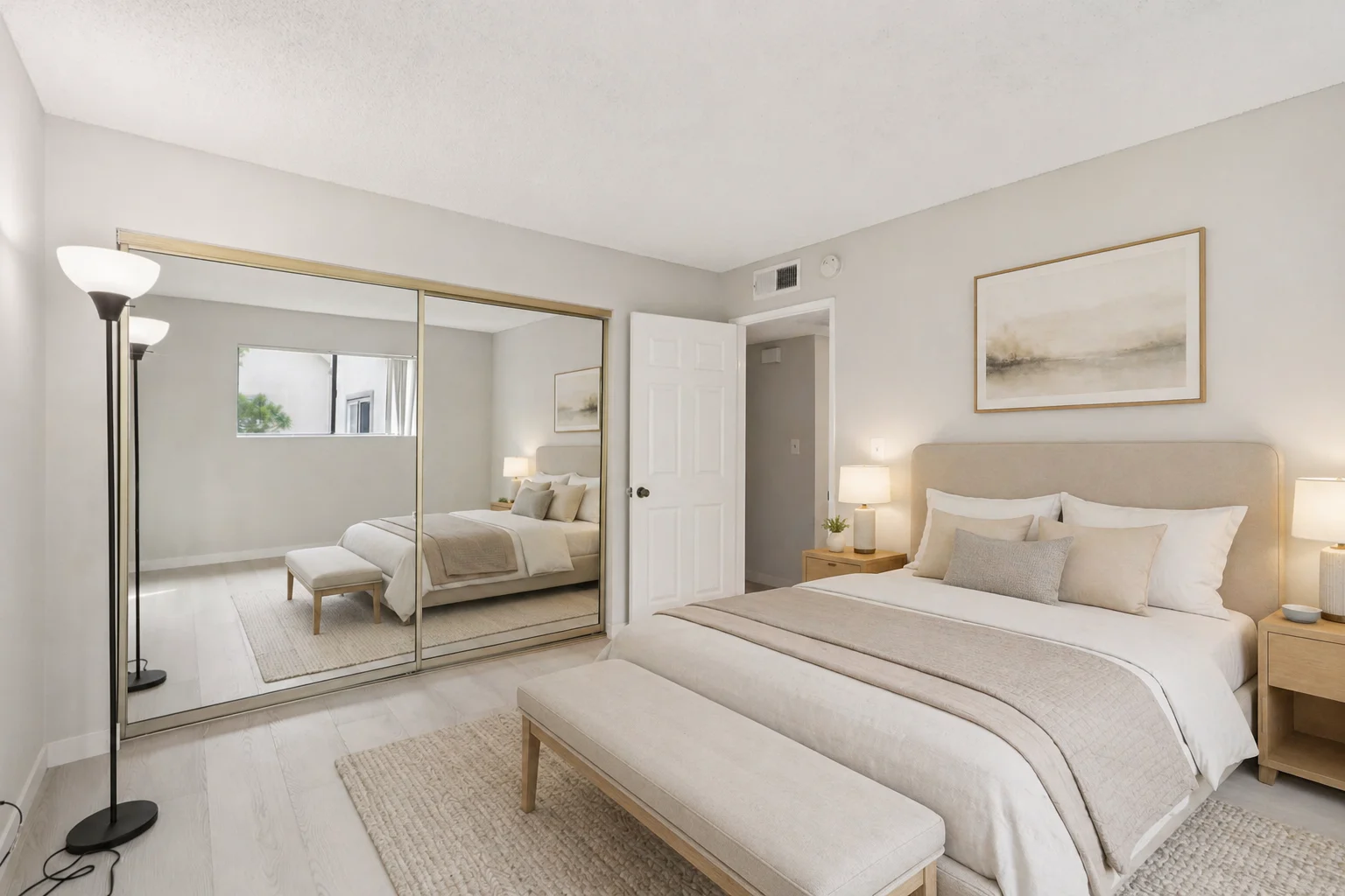 The same Park Providencia bedroom virtually staged by GPT Image 2.0 with a queen size bed against the right wall featuring a soft upholstered beige headboard, layered white and beige bedding with grey accent pillows, two minimal wood bedside tables with small ceramic lamps, an upholstered bench at the foot of the bed, a textured cream area rug under the bed, framed minimalist landscape art above the headboard, and the mirrored sliding closet on the left preserved exactly with realistic reflections of the staged room