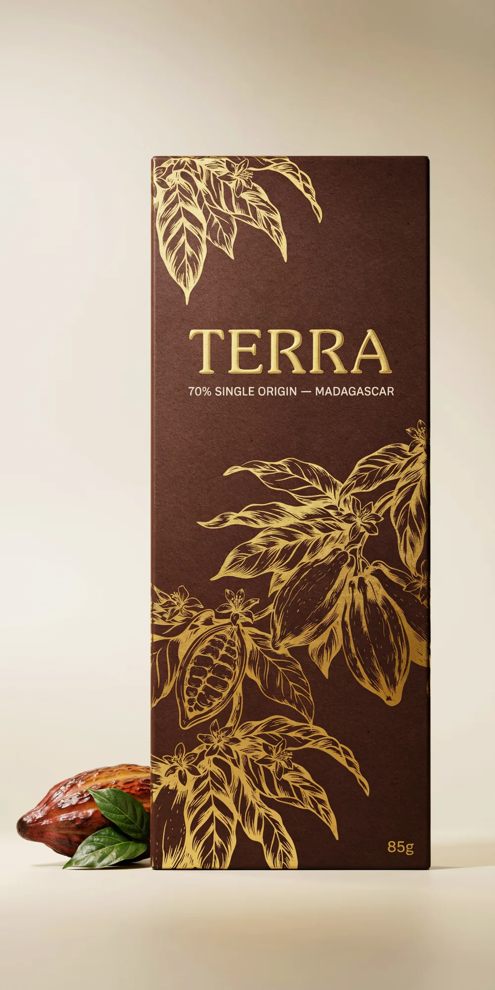 Worked Ideogram 4.0 output: TERRA premium chocolate bar packaging mockup, "TERRA" in gold foil display serif with debossed effect, "70% Single Origin - Madagascar" small caps cream sans-serif tagline, "85g" gold foil sans-serif weight callout, deep brown wrapper with hand-illustrated gold foil botanical pattern, studio product photography